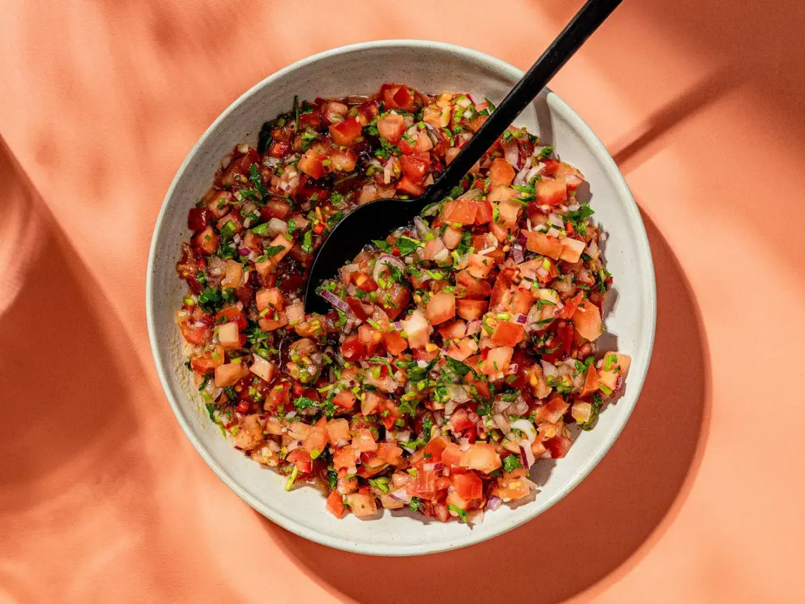 En skål med färsk pico de gallo, en härlig blandning av hackade tomater, lök och koriander, redo att serveras.