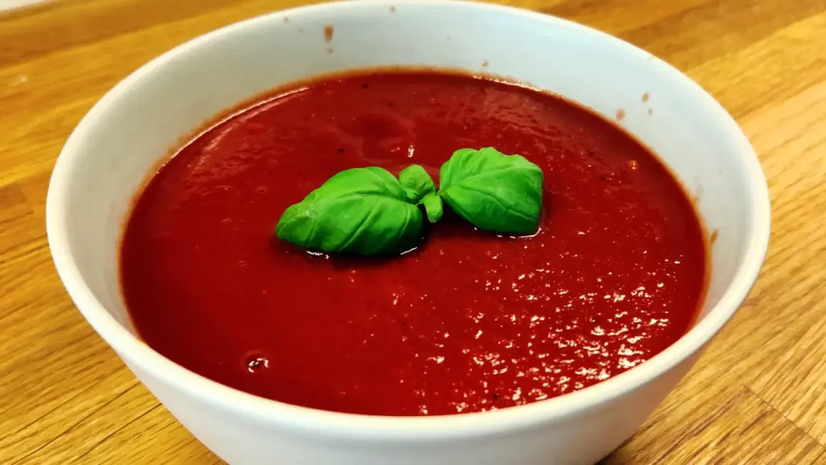 En skål med tomatsoppa, så röd att den nästan ser ut som el diablo. Garnerad med färsk basilika.