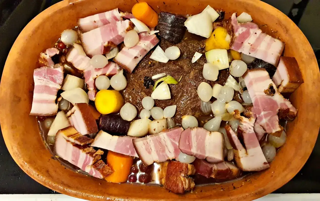 En saftig kyckling i lergryta med bacon, sm&aring; l&ouml;kar, mor&ouml;tter och rotfrukter. En h&auml;rlig doft sprider sig fr&aring;n den varma grytan.