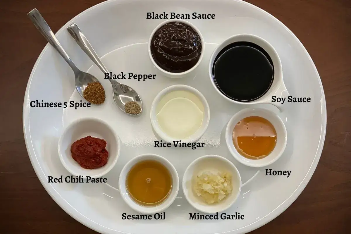 Ingredienser för hoisinsås recept: svart bönpasta, sojasås, risvinäger, honung, sesamolja, vitlök, chilipasta, kinesisk femkrydda, svartpeppar.