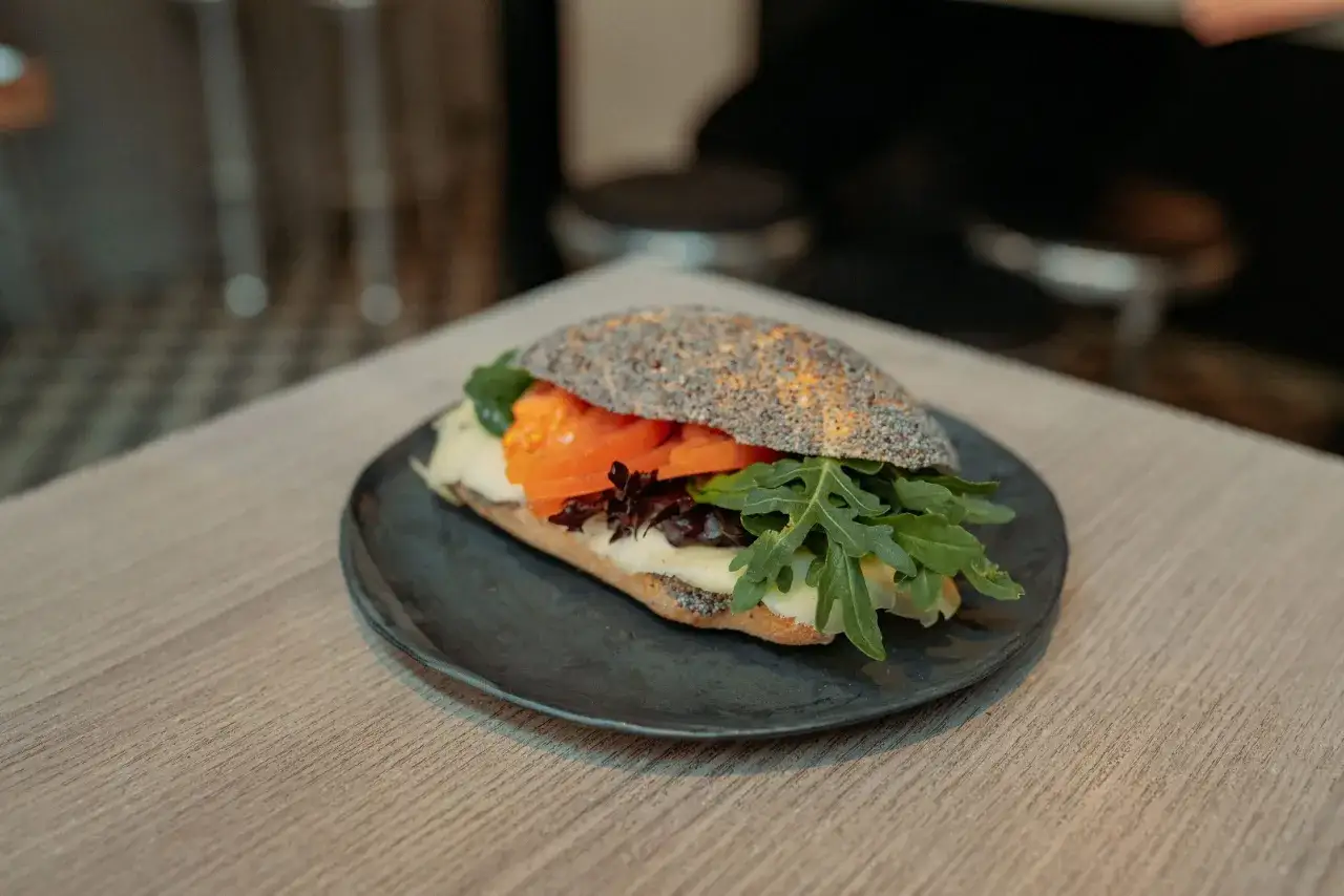 En härlig macka med sallad, tomat och ost på ett mörkt bröd med vallmofrön. Perfekt för en god lunch.