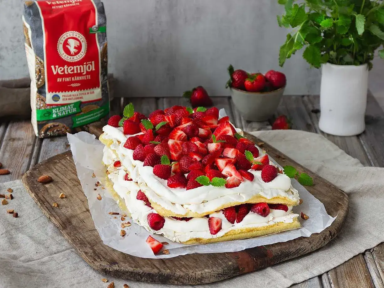 En stor pinocchiotårta i långpanna med grädde och färska jordgubbar. Perfekt för sommaren!