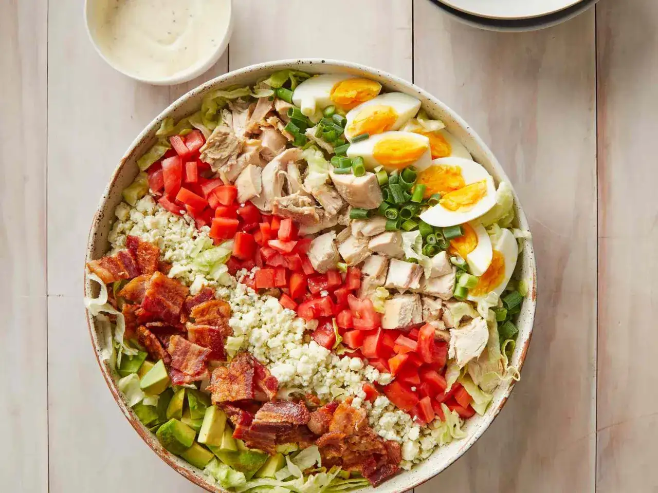 En stor cobb salad med kyckling, bacon, &auml;gg, tomat, avokado och bl&aring;m&ouml;gelost. Serveras med en kr&auml;mig dressing.
