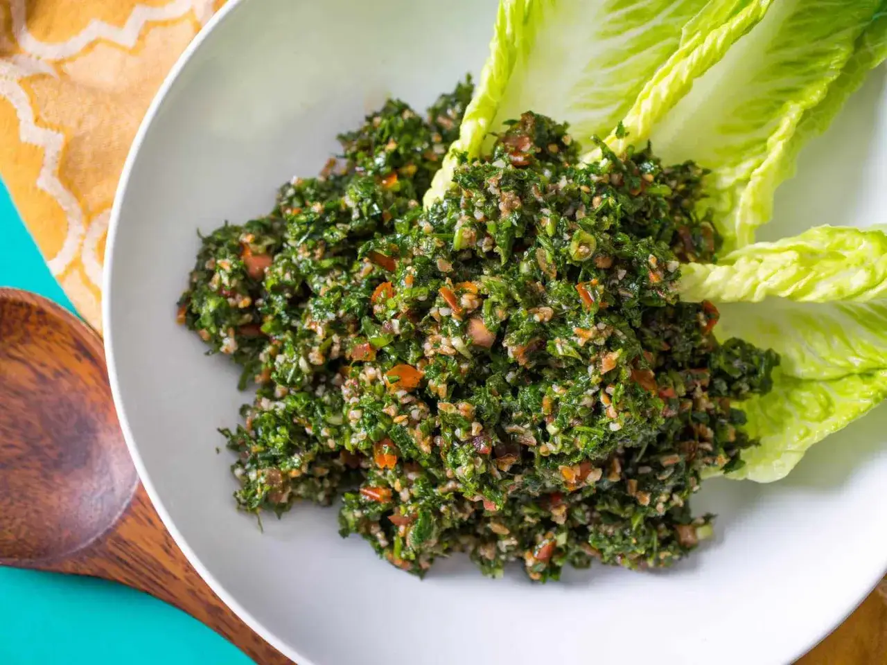 En skål med färsk tabbouleh, perfekt för ett lätt lunchrecept. Serveras med krispiga salladsblad.