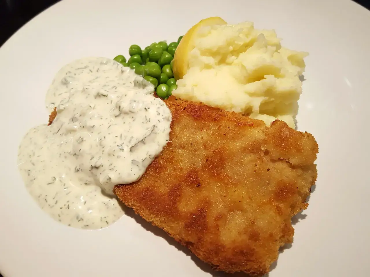 Panerad fisk med potatismos, gröna ärtor och en generös klick av skolans kalla fisksås.