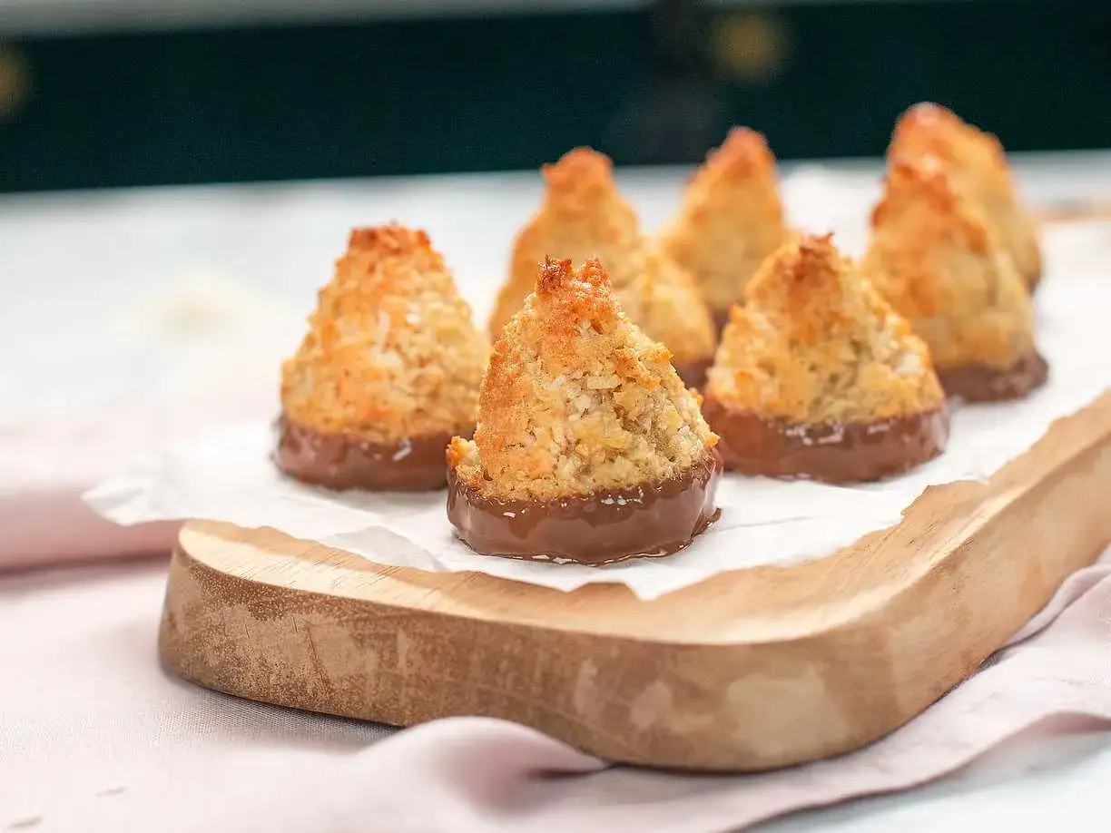 Små, gyllene kokostoppar med chokladbotten, perfekta för ett enkelt kokostoppar recept.
