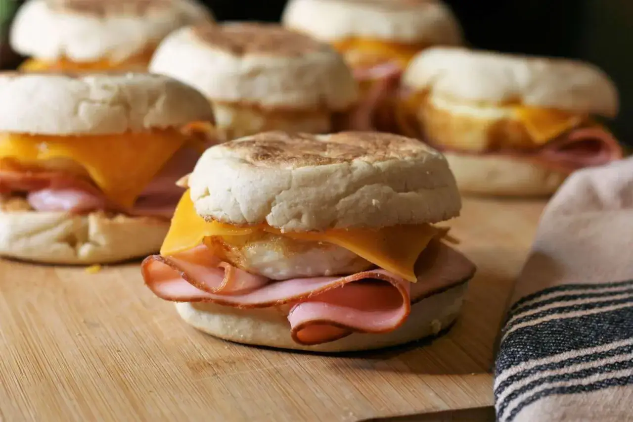 Frukostmackor med skinka, ost och ägg, som en enklare croque madame, ligger på en skärbräda.