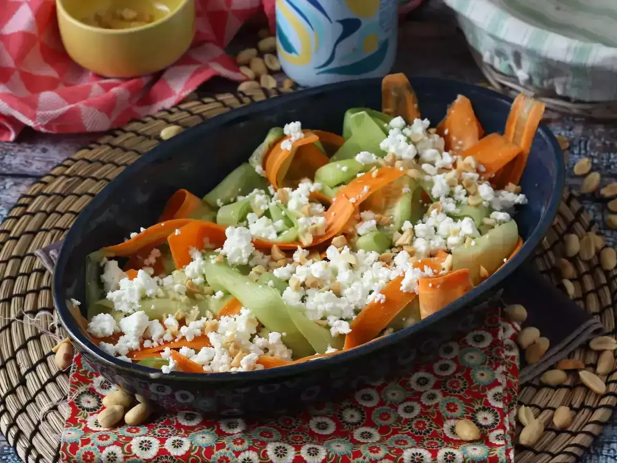 En härlig god sallad till maten med strimlad morot, gurka och smulad fetaost, toppad med hackade nötter.