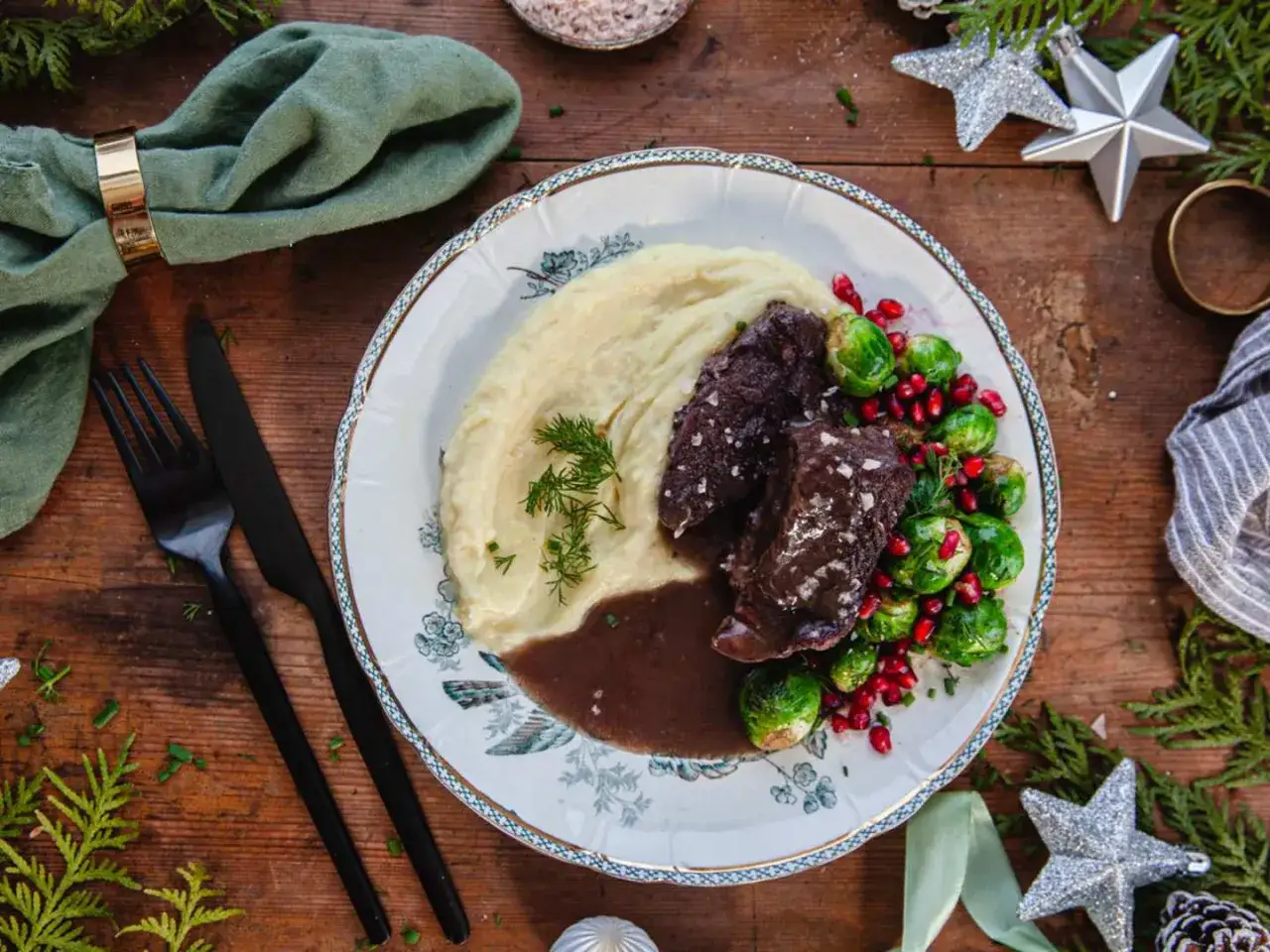 En festlig tallrik med oxkind, potatismos, brysselkål och granatäpple. Ett perfekt oxkind recept för högtider.