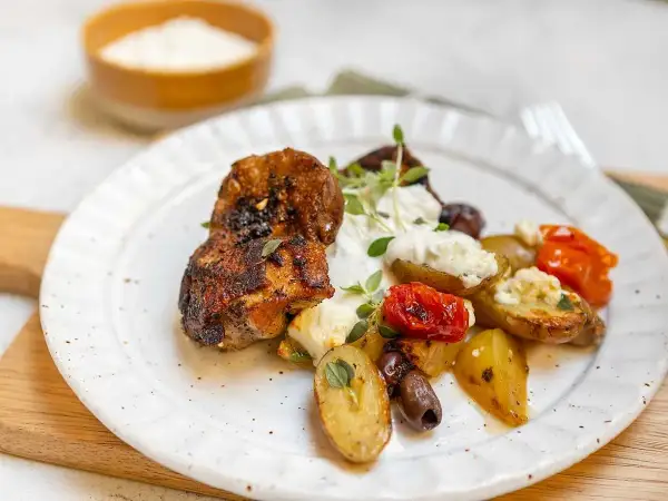 Krispiga kycklingbitar med rostade potatisar, tomater, oliver och en krämig sås till kyckling.