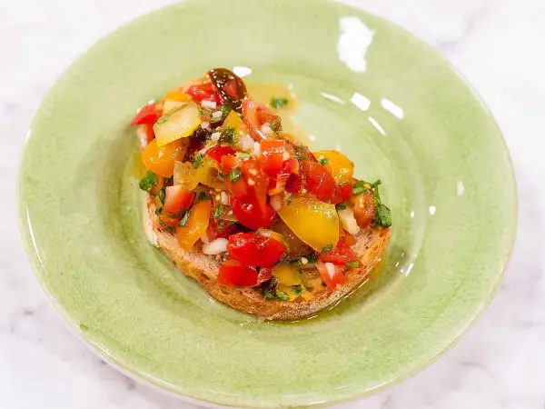 En härlig bruschetta med färska tomater, lök och örter på rostat bröd. Ett enkelt och gott bruschetta recept.