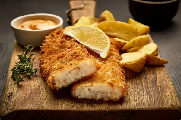 Krispigt panerad fisk med klyftpotatis, citron och en krämig sås. En klassisk rätt som alltid går hem.
