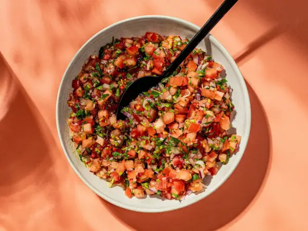 En skål med färsk pico de gallo, en härlig blandning av hackade tomater, lök och koriander, redo att serveras.