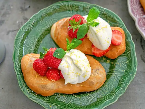 Två friterade langos med grädde, färska jordgubbar och mynta. Ett enkelt langos recept för en härlig fika.